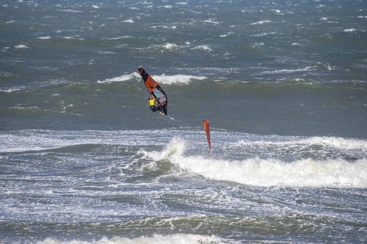 Windsurfer in de golven bij harde wind