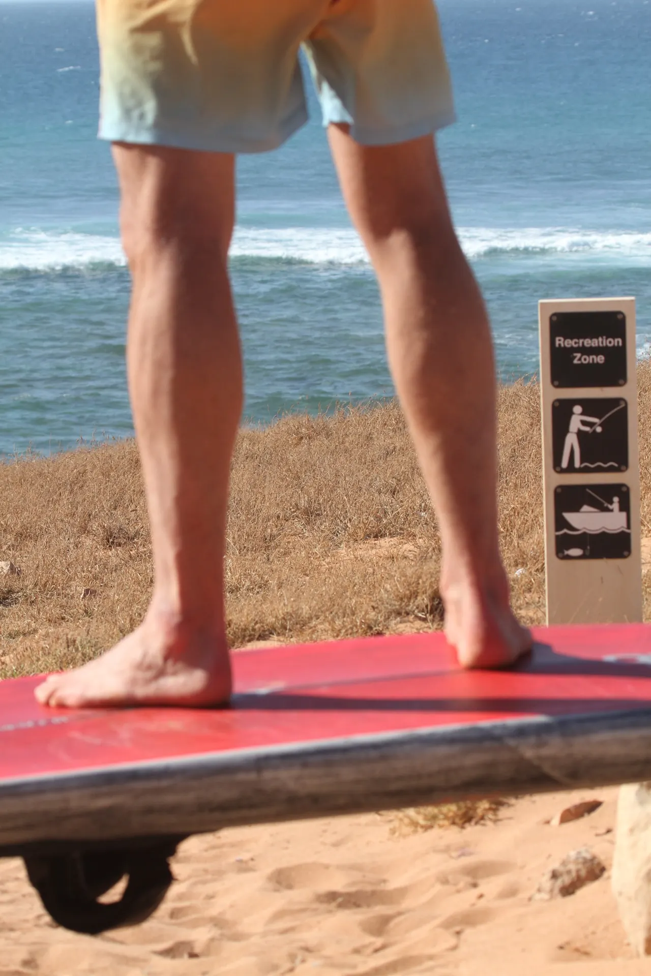 Op blote voeten naast het board op het strand