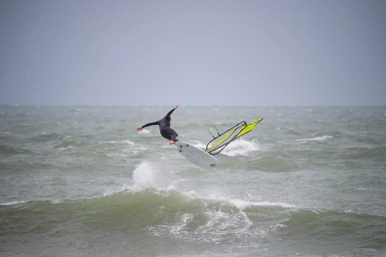 Windsurfer maakt een sprong in het schuim