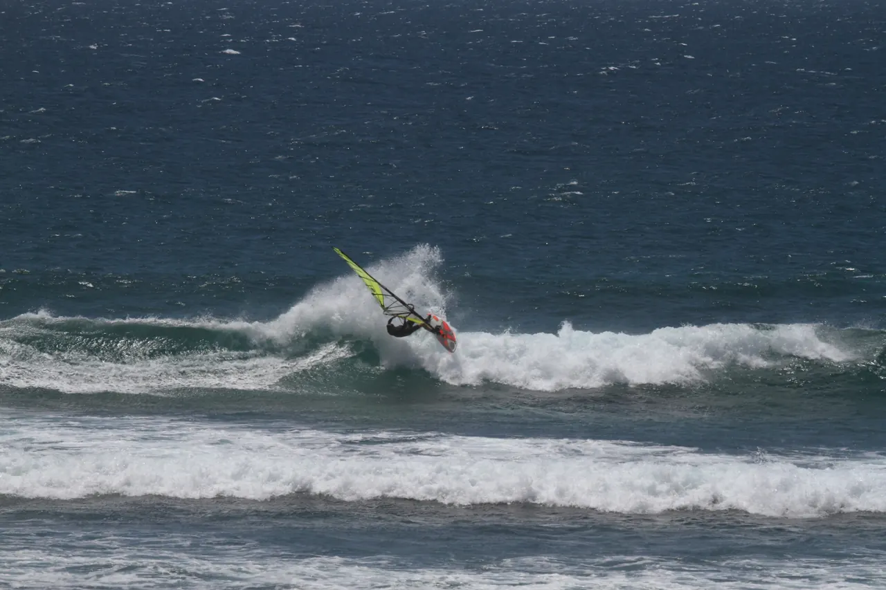 Windsurfer slaat een top turn op een golf