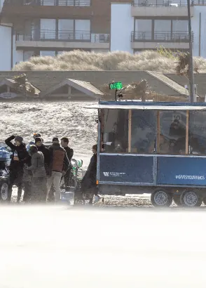Toeschouwers aan de jurywagen op het strand